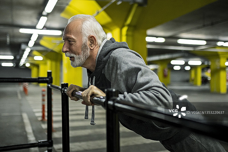 在停车场做俯卧撑的年长运动男士图片素材