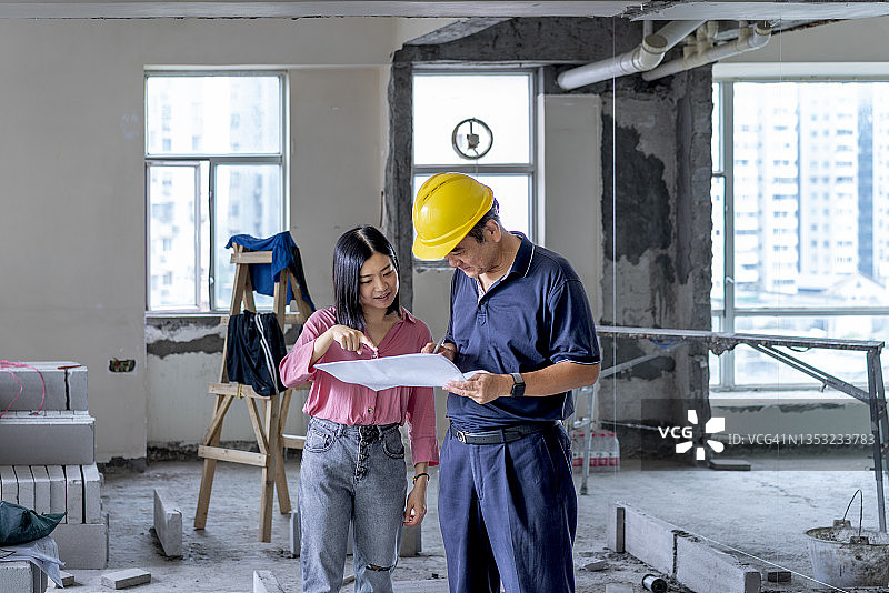 室内设计师在装饰房屋与建筑工人交流图片素材