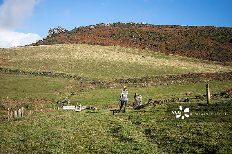 女士和狗在山丘上散步图片素材