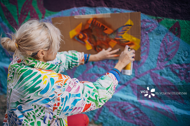 街头艺术家在建筑墙上喷绘图片素材