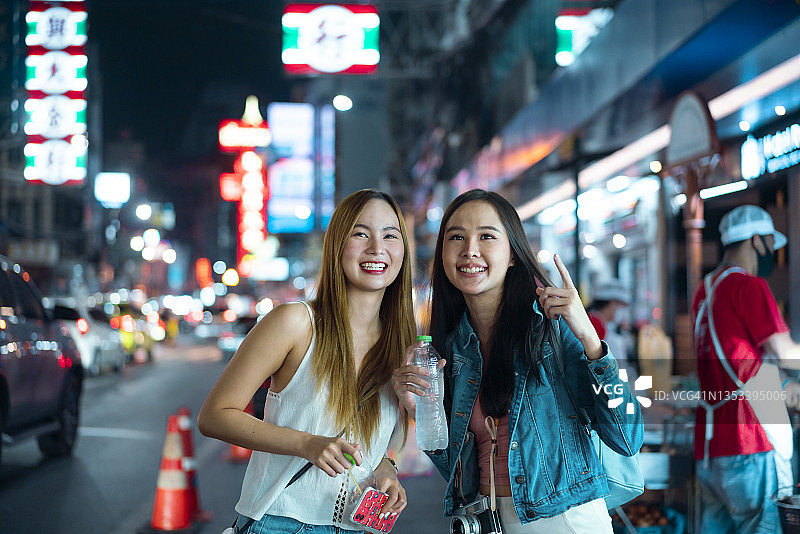 年轻的亚洲女游客肩上背着背包，戴着旅游帽走在中国城曼谷的步行道上图片素材