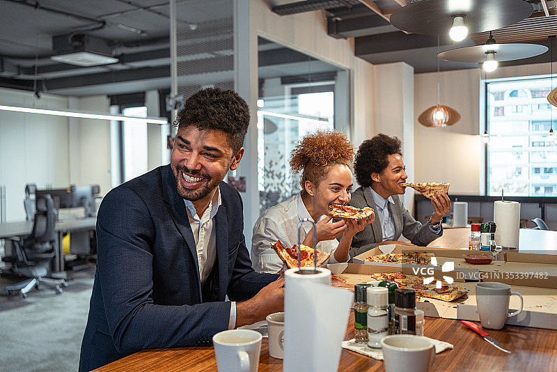 在自助餐厅午休吃披萨的多民族商务人士图片素材
