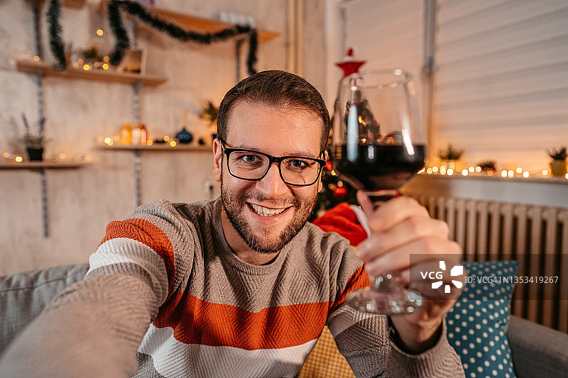 微笑的男人举着酒杯自拍图片素材