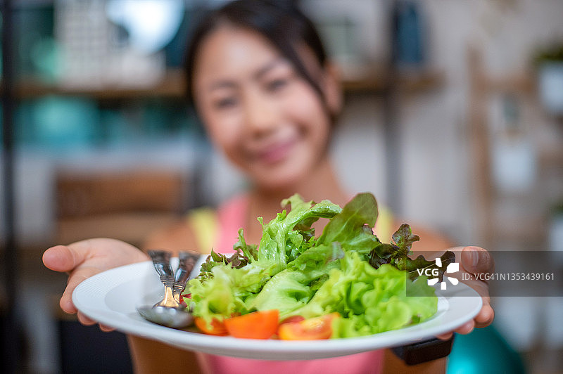 在家锻炼后吃健康沙拉的女人图片素材