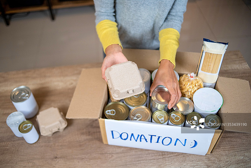 一个人正在用食品包装捐赠箱图片素材