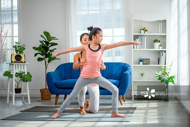 健身：在运动俱乐部，瑜伽老师指导学生进行伸展练习，指导女学生在课堂上做瑜伽图片素材