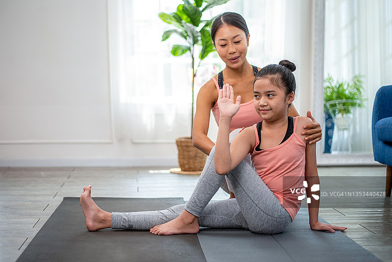 健身：在运动俱乐部，瑜伽老师指导学生进行伸展练习，指导女学生在课堂上做瑜伽图片素材