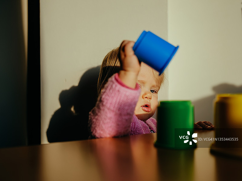 在阳光下玩耍彩色叠叠杯的创意幼儿图片素材