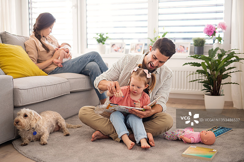 幸福的年轻家庭与新生儿和女儿在家共度时光图片素材