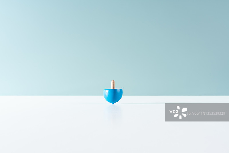 蓝色背景上旋转的陀螺图片素材