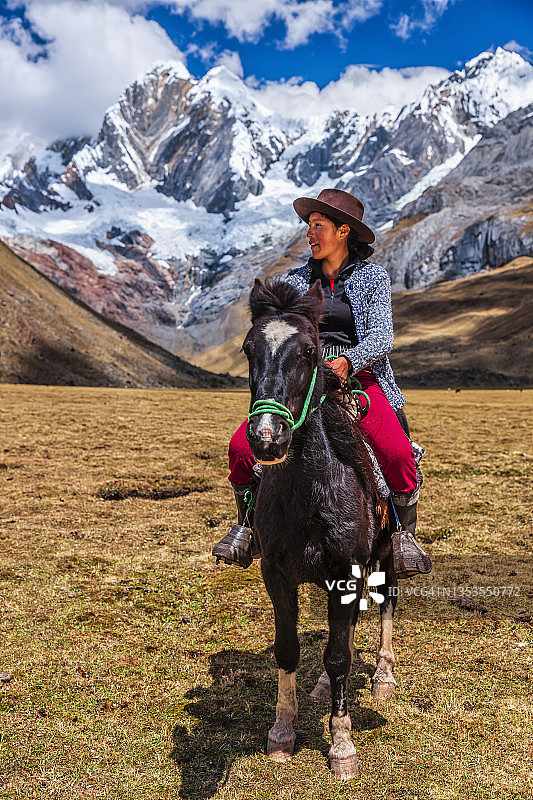 年轻女孩在秘鲁安第斯山脉骑马图片素材
