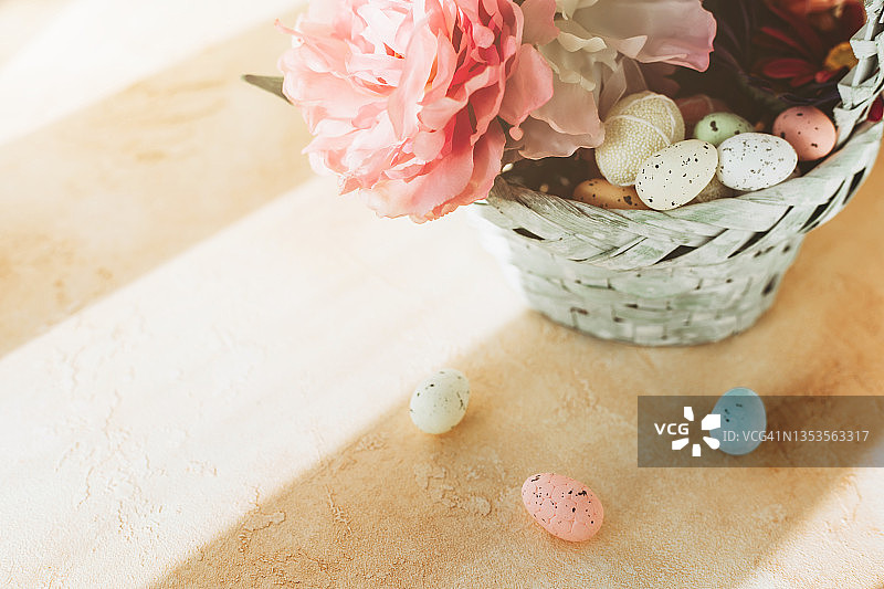 装满鲜花和鸡蛋的绿松石色复活节柳条筐图片素材