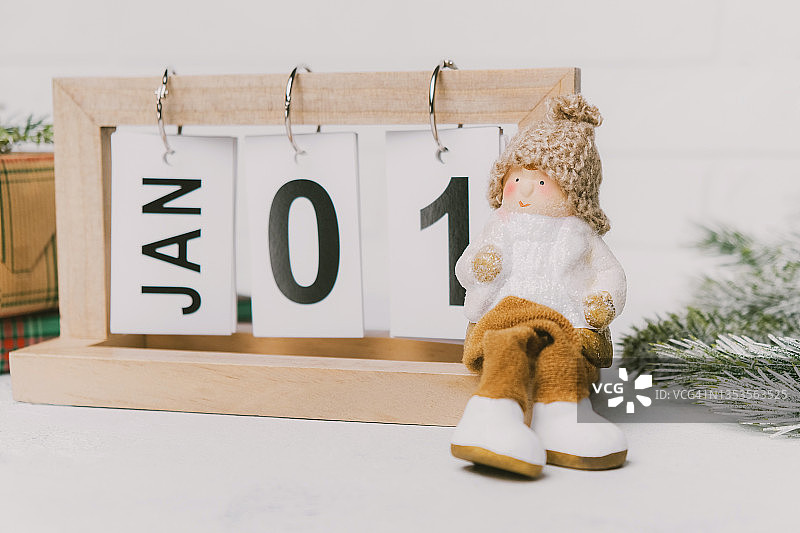 坐在日历、松枝和礼品盒上的圣诞侏儒图片素材