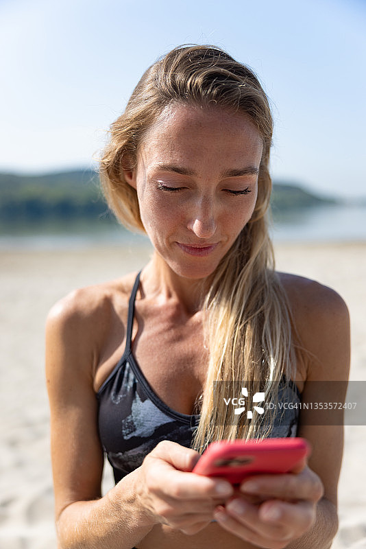 在海滩上查看手机通知的女人图片素材