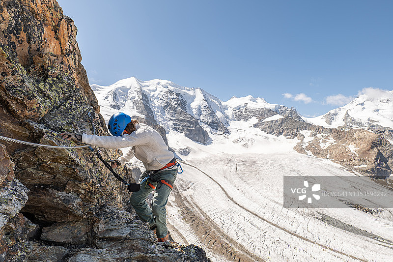 在冰川上攀登铁索攀岩的男人图片素材