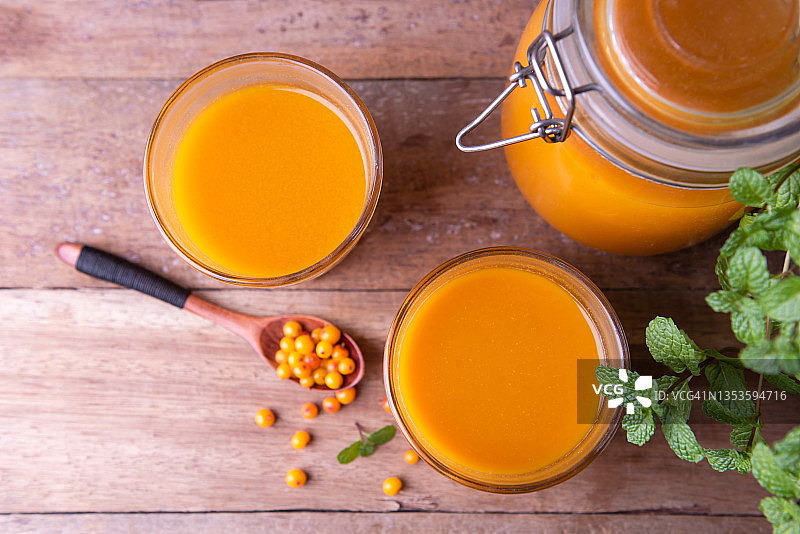 老木桌上的沙棘果汁和新鲜浆果图片素材