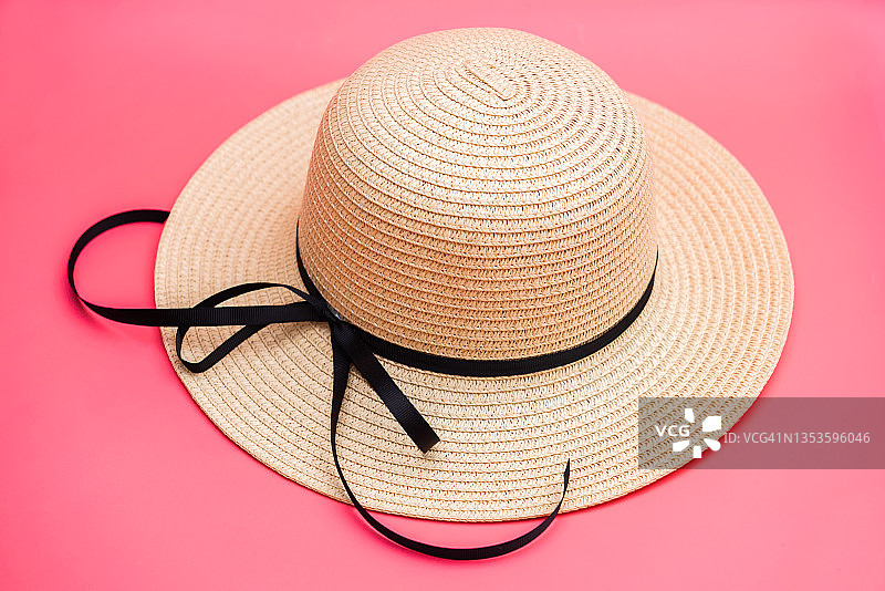 粉色背景上的丝带草帽图片素材