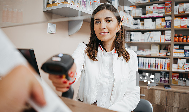 在药店使用条形码扫描器的女人图片素材