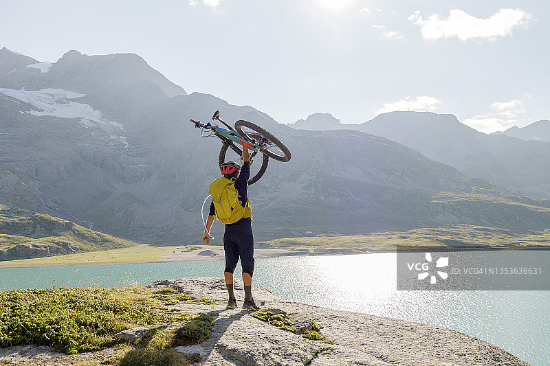 男人扛着自行车登山图片素材