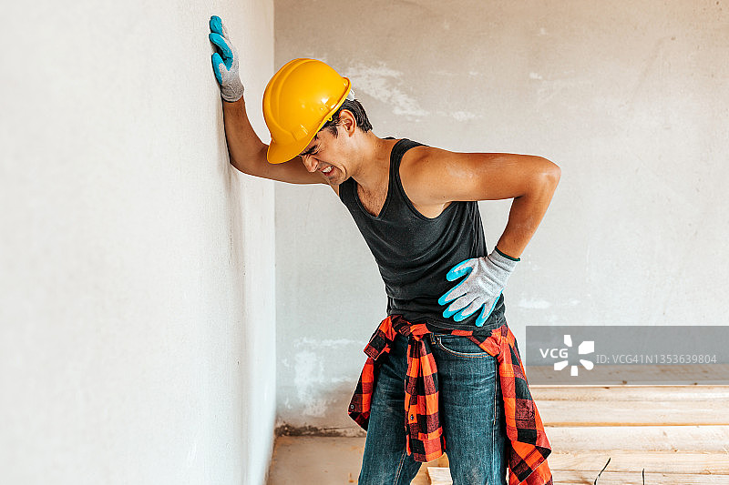 建筑工地腰痛的年轻工人图片素材