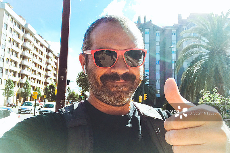 中年男人在街上竖起大拇指微笑图片素材