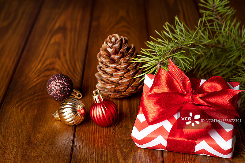 圣诞主题构图：礼物、装饰球和松果的木质背景图片素材