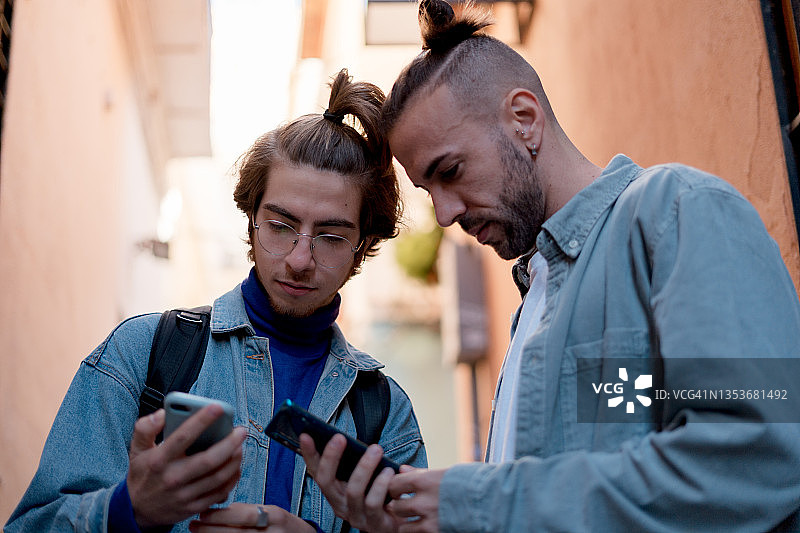 两个朋友在城市里用手机寻找地点图片素材