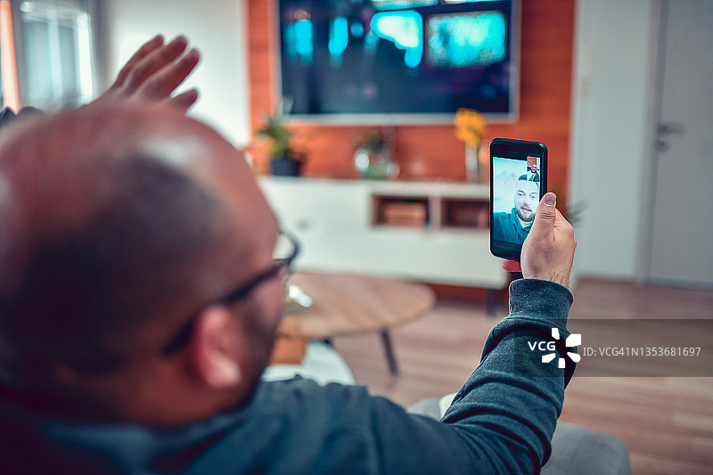 在家进行视频会议的秃顶男人和英俊的朋友图片素材