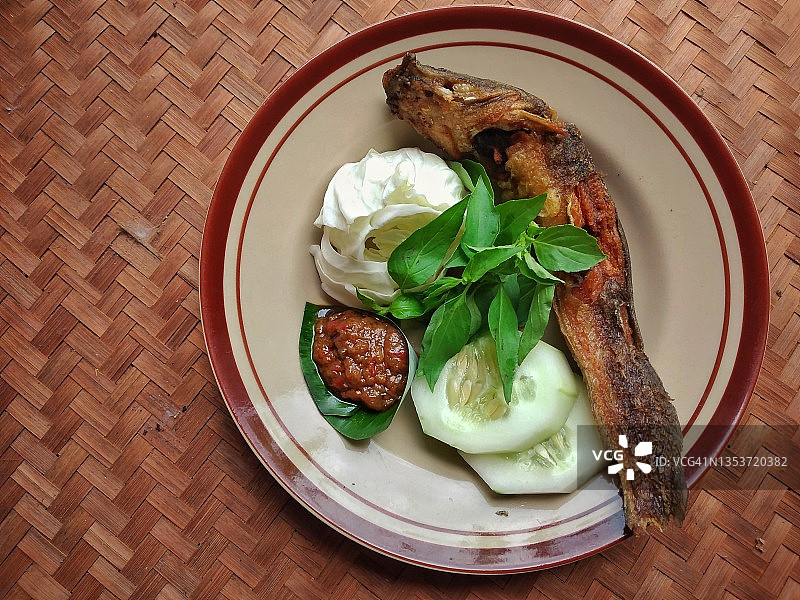 印尼传统美食：炸鲶鱼配新鲜蔬菜和辣椒酱图片素材