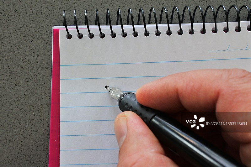 开始用黑色钢笔在空白螺旋日记本上写遗愿清单的人图片素材