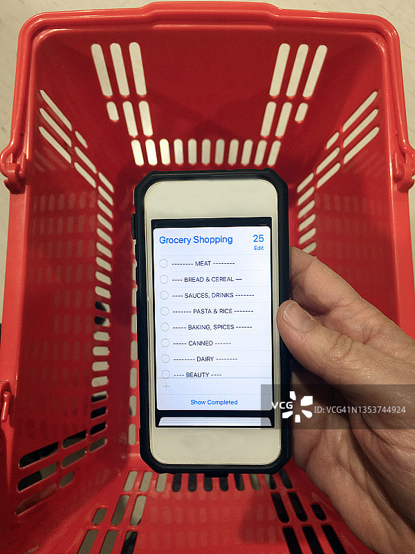 人物手持手机，显示购物清单图片素材