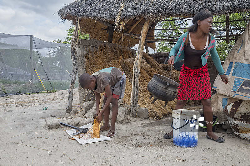 在农场工作和做饭的拿着斧头的非洲儿童图片素材