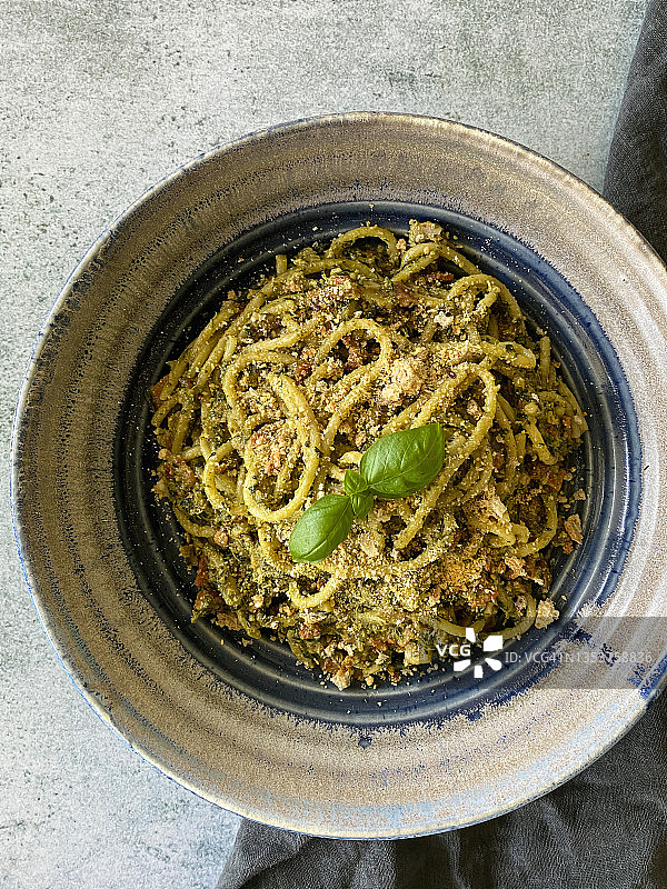 自制香蒜意面特写：面包屑和罗勒叶点缀图片素材