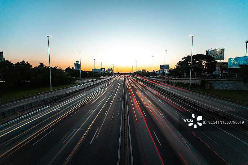 城市黄昏时分高速公路上行驶的车辆高视角景观图片素材