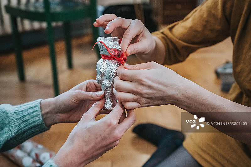 女性手部用红色丝带装饰巧克力熊图片素材