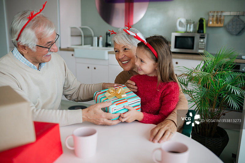 快乐的白人祖父母与孙女一起庆祝冬季节日图片素材