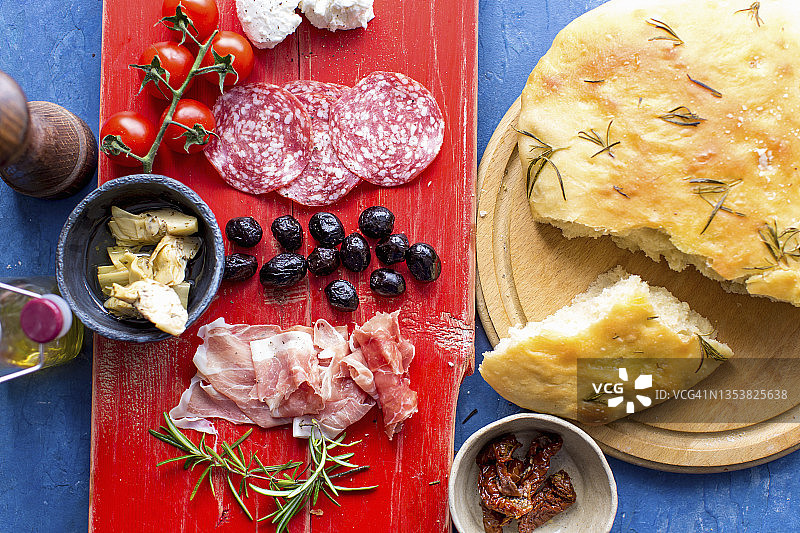 开胃小吃：迷迭香佛卡夏、茴香萨拉米香肠、番茄、朝鲜蓟、黑橄榄和火腿图片素材