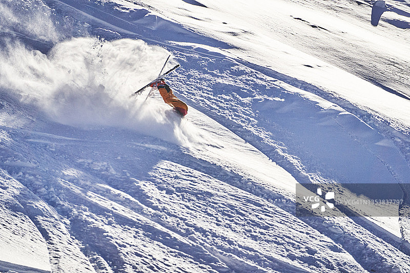 滑雪者在雪山上高速摔倒图片素材