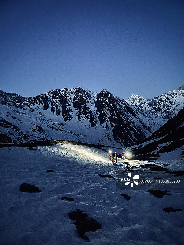 黎明前在雪坡上滑雪的朋友图片素材