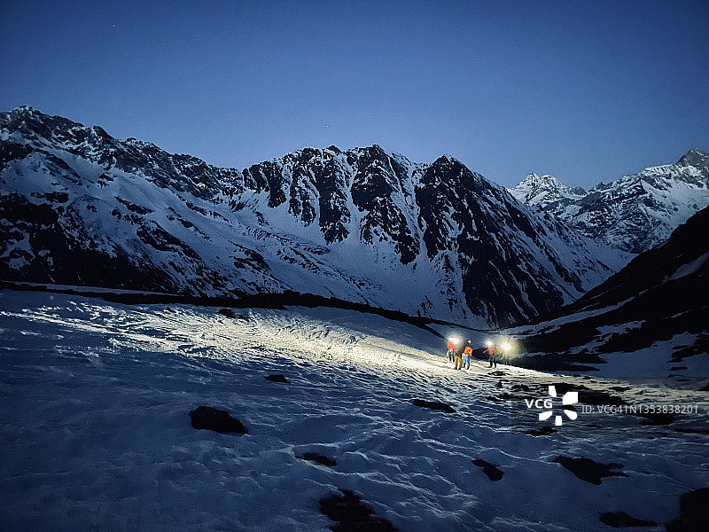 黎明前在雪坡上滑雪的朋友图片素材