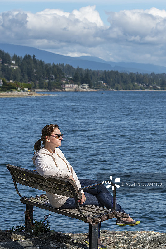 秋季，在沿海悬崖上放松的徒步女性图片素材
