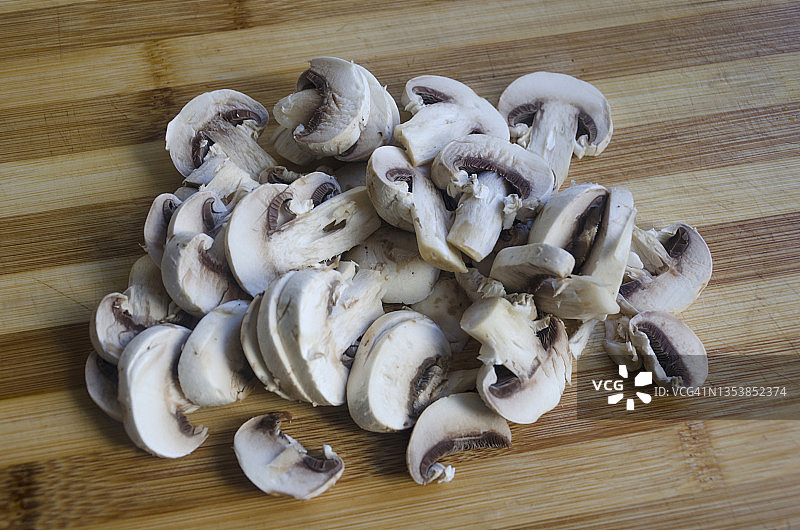 木制砧板上的新鲜白色生香菇切片图片素材