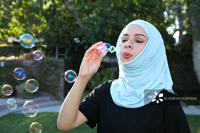 中东年轻女子吹泡泡（横版）图片素材