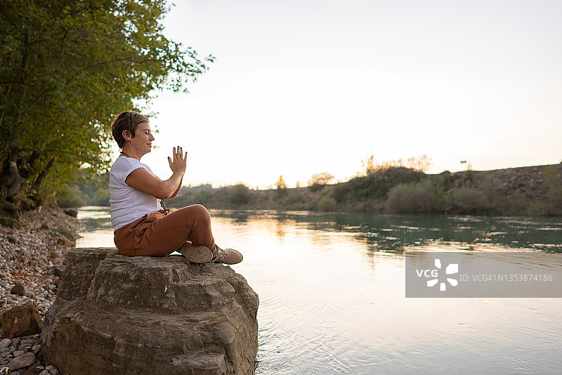 在湖边冥想的美丽的精神女性图片素材