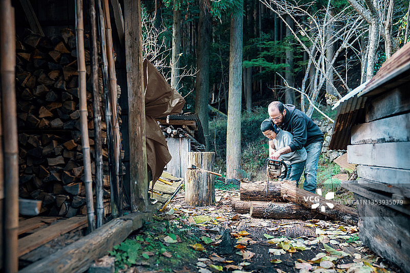 父亲教儿子如何使用油锯图片素材
