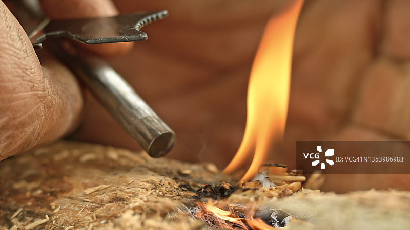 男人使用打火棒和刀点燃火图片素材