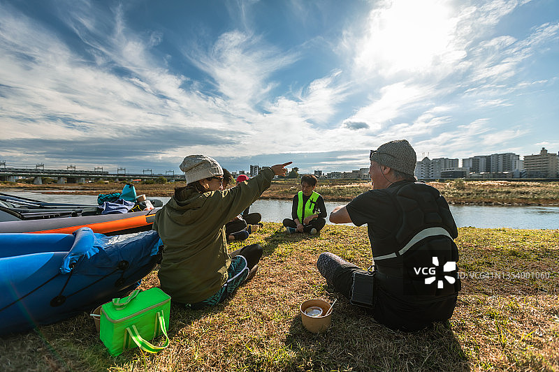 一群成年人在城市河流上享受划独木舟和桨板运动图片素材
