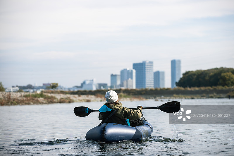 一群成年人在城市河流上享受划独木舟和桨板运动图片素材