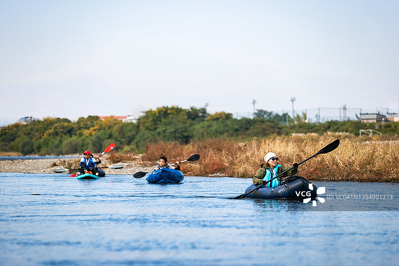 一群成年人在城市河流上享受划独木舟和桨板运动图片素材