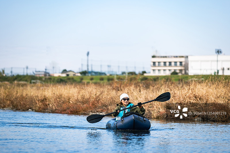 一群成年人在城市河流上享受划独木舟和桨板运动图片素材